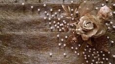 a flower is sitting on the side of a wooden wall with beads and leaves around it