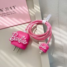 two pink hair pins with the word barbie on them