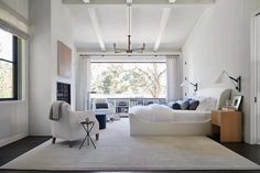 a bedroom with white walls and wood flooring has a large bed in the center