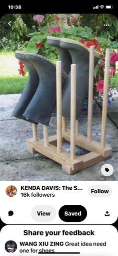 four boots are lined up on a wooden stand with flowers in the back ground behind them