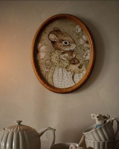 a clock mounted to the side of a wall next to teapots and cups