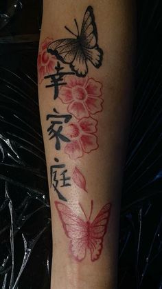 a woman's leg with flowers and butterflies tattooed on the side of her leg