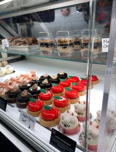 a display case filled with lots of different types of cakes and cupcakes on top of each other