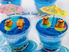 there are three cups with teddy bears in the water and one is holding an umbrella