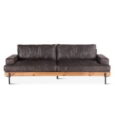 a gray leather couch with wooden legs