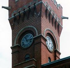 a large brick clock tower on top of a building with a sky in the background