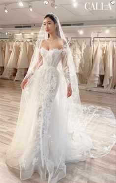 a woman standing in front of a wedding dress