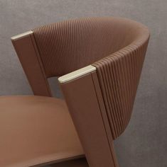 a close up of a chair with a brown leather seat and armrests on it