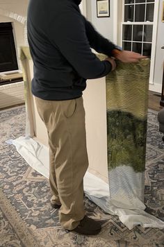 a man standing in front of a rug on top of a blue and white carpet