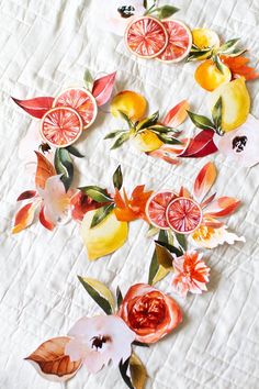 paper cut flowers and fruit on a white quilt