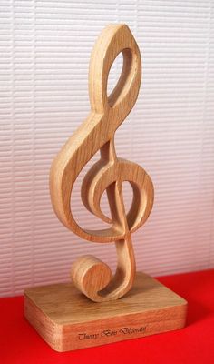 a wooden music note sculpture sitting on top of a red table