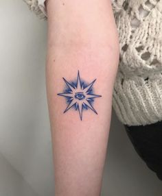 a woman's arm with a blue tattoo on it and an all seeing eye