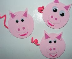 three pink pig shaped magnets on a white surface