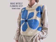 a woman wearing a sweater with blue flowers on it and the words make my self flowers vest next to her