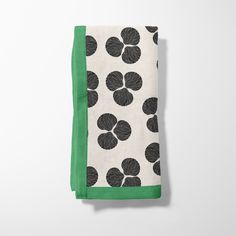 a green and white towel with black flowers on it