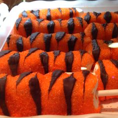 there are many orange desserts with chocolate drizzled on them in the tray