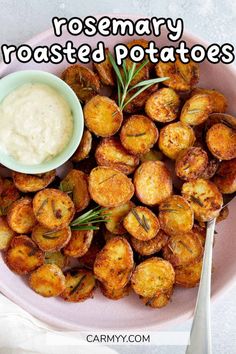 rosemary roasted potatoes on a pink plate with a bowl of ranch dressing