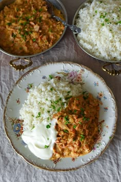 two bowls filled with rice and some type of curry next to another bowl full of white rice