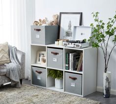 a living room filled with lots of furniture and storage bins on top of each other