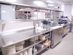 a commercial kitchen with stainless steel appliances and dishes