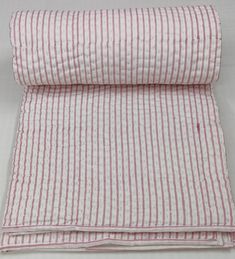 the pink and white striped fabric is rolled up on top of it's side