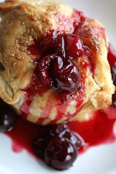 a pastry with cherries and sauce on it