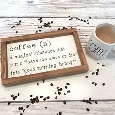 a cup of coffee sitting next to a framed sign