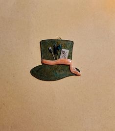 a green hat with pins attached to the brim and two other things on it