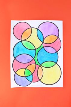 an art project made with colored paper and watercolors on a red background, depicting circles