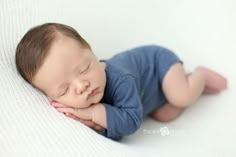 a baby is laying on its side with his eyes closed