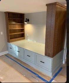 an empty room with cabinets and drawers in the middle, being painted blue tape on the floor