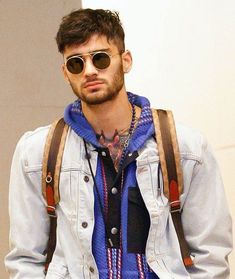 a young man wearing sunglasses and a denim jacket