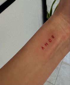 a woman's arm with the word roma tattooed on it