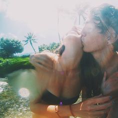 two women in bathing suits kissing each other