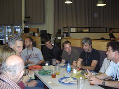 a group of men sitting around a table eating food