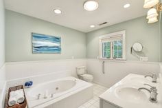 a bathroom with a tub, toilet and sink in it's center piece is shown