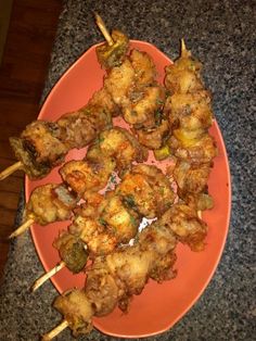 several skewers of food sitting on an orange plate