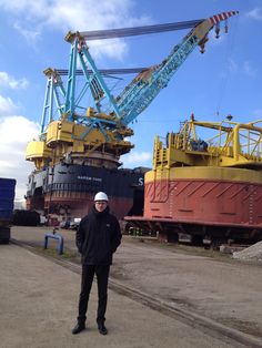 a man standing in front of a large crane