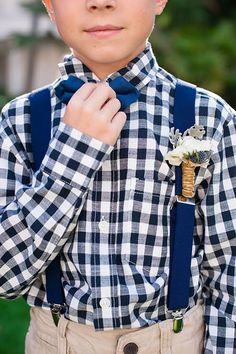 a young boy wearing suspenders and a bow tie