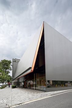 a large building with a triangular roof on the street