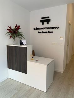 a white reception desk with flowers on top