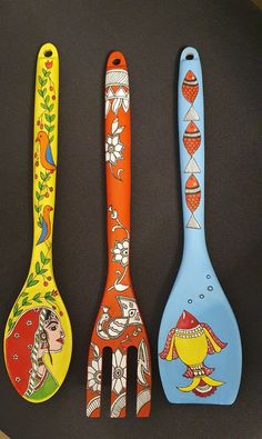 three colorful spoons with designs on them are lined up in a row and one has a fork sticking out of it