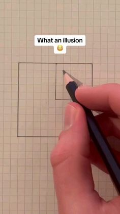 someone is holding a pencil in front of a square with an emoticion on it