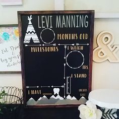 a chalk board with the words levi manning on it next to some flowers and other decorations