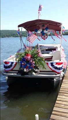 a boat with american flags on it docked at a pier