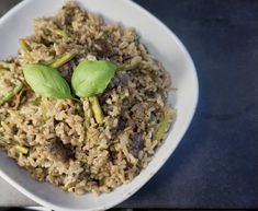 a white plate topped with rice and asparagus on top of a blue table