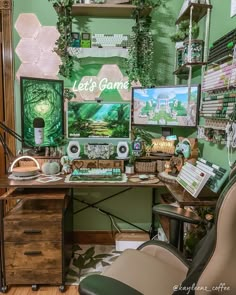 a desk with lots of items on it in front of a green wall and shelves