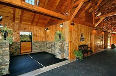 the inside of a building with wood paneling and stone accents on the walls, along with black rugs