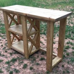 a wooden table sitting on top of a grass covered field