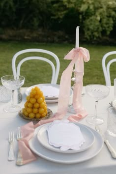 a table set with plates, silverware and napkins for an outdoor wedding reception